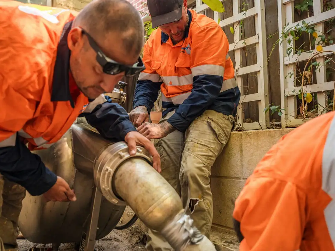 Technicians feeding a liner into the installation equipment.