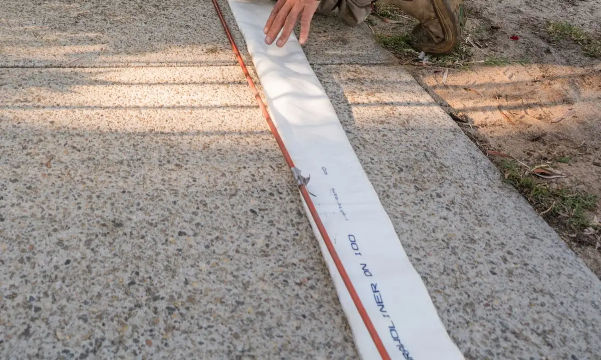 A prepared liner laid along the footpath before installation.